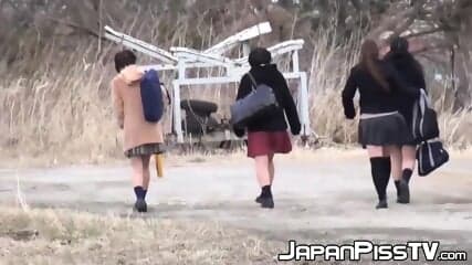 Four Japanese schoolgirls fool around outside before peeing